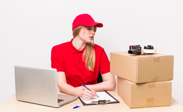 Female packing employee working beside cardboard boxes