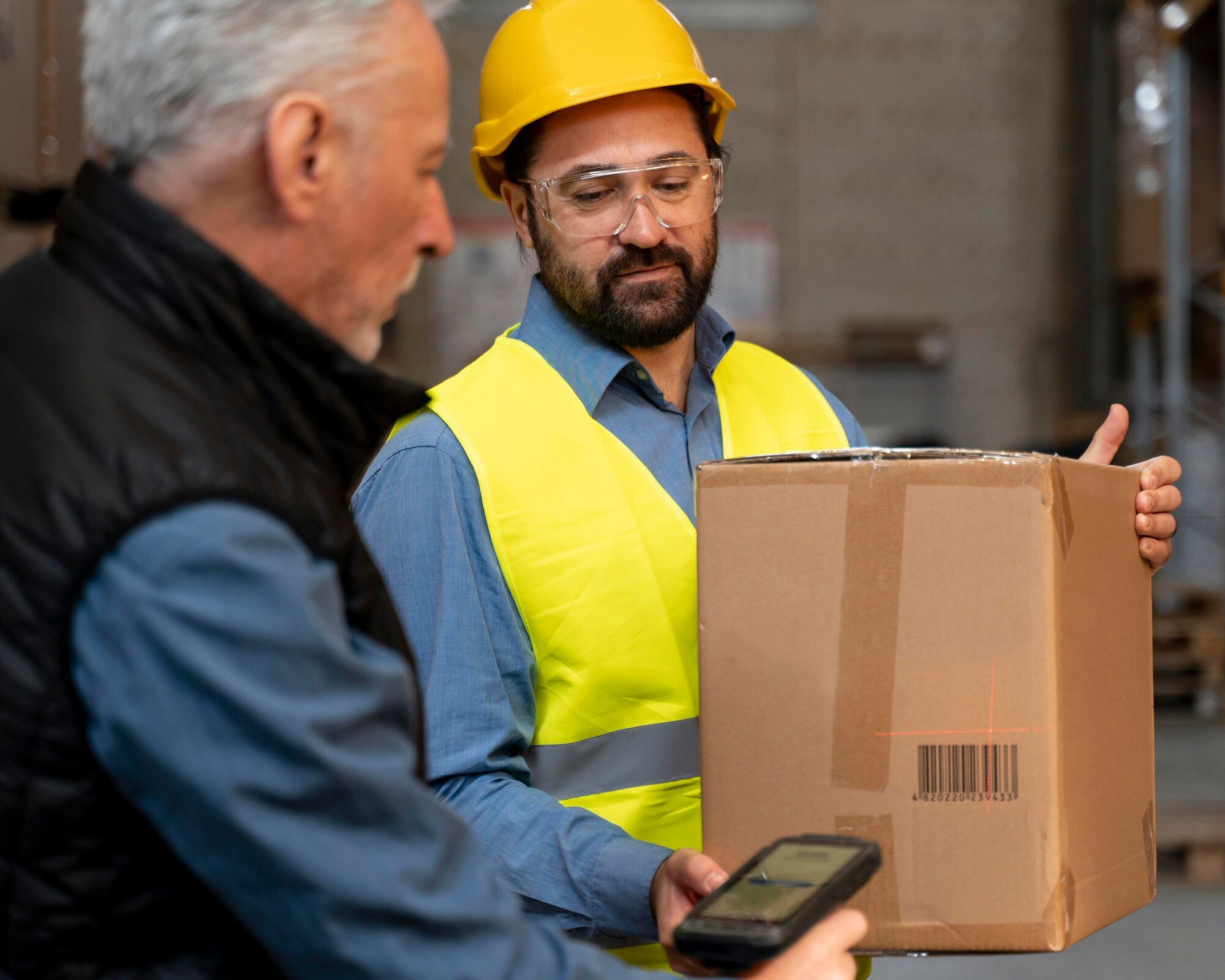 Warehouse employees handling and inspecting a cardboard package