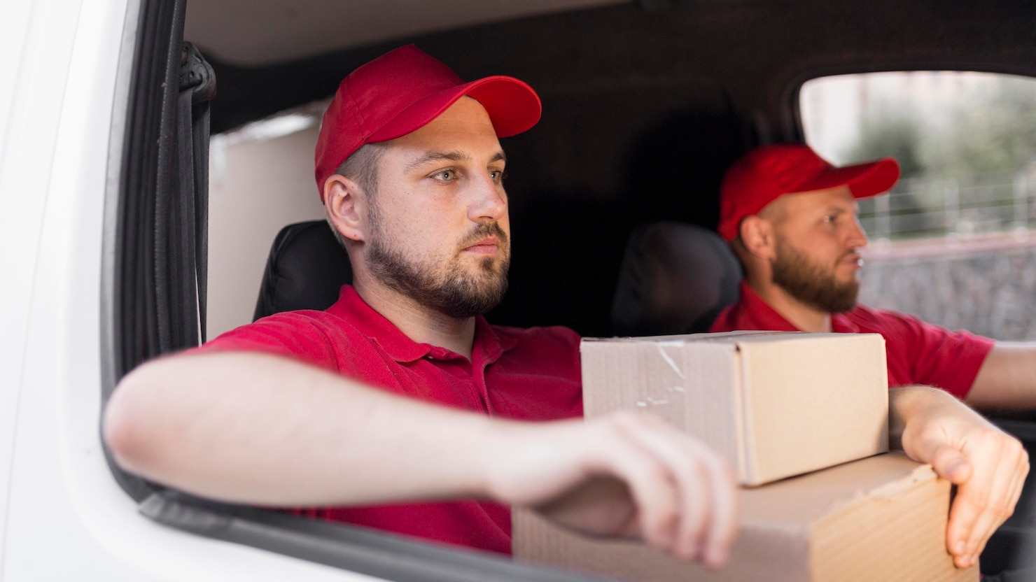 Delivery driver wearing a red cap and uniform