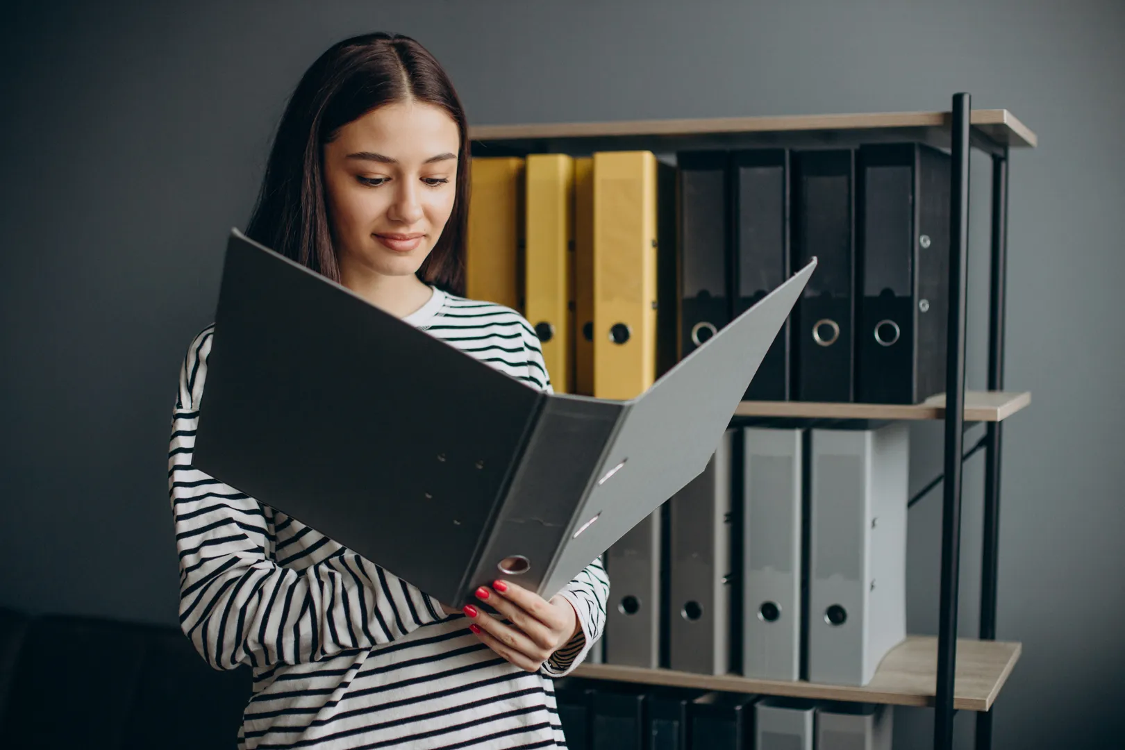 Female warehouse employee checking inventory on storage shelves