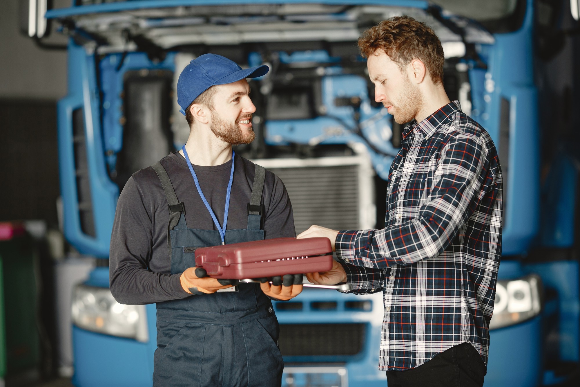 Two uniformed workers discussing information on a tablet